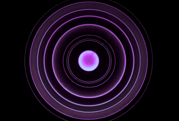 A pink orb has a series of lit up radiating circles flowing out on a dark background.